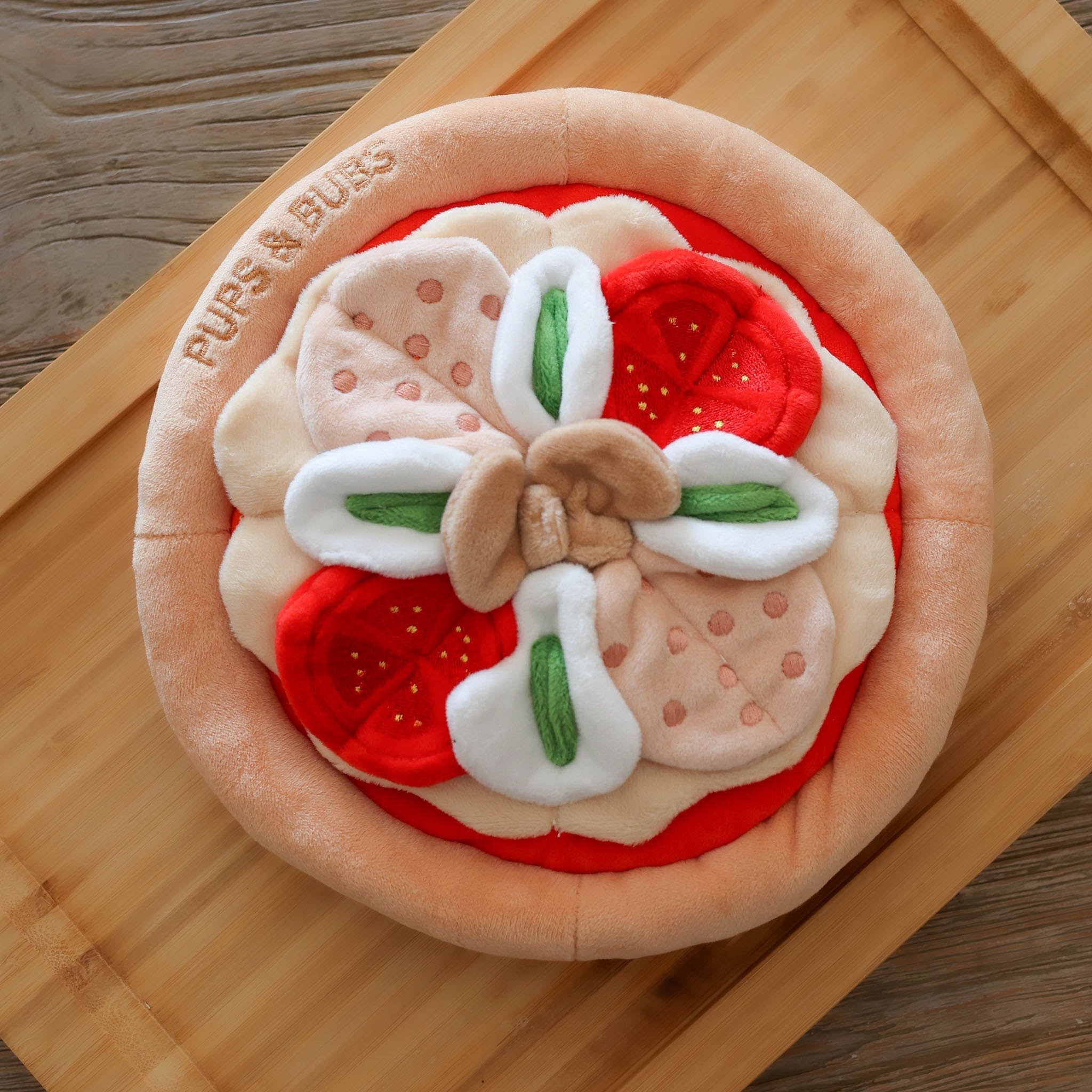 Overhead product view of the round pepperoni pizza snuffle mat by pups & bubs, a high-quality plush dog foraging mat featuring interactive fabric toppings.