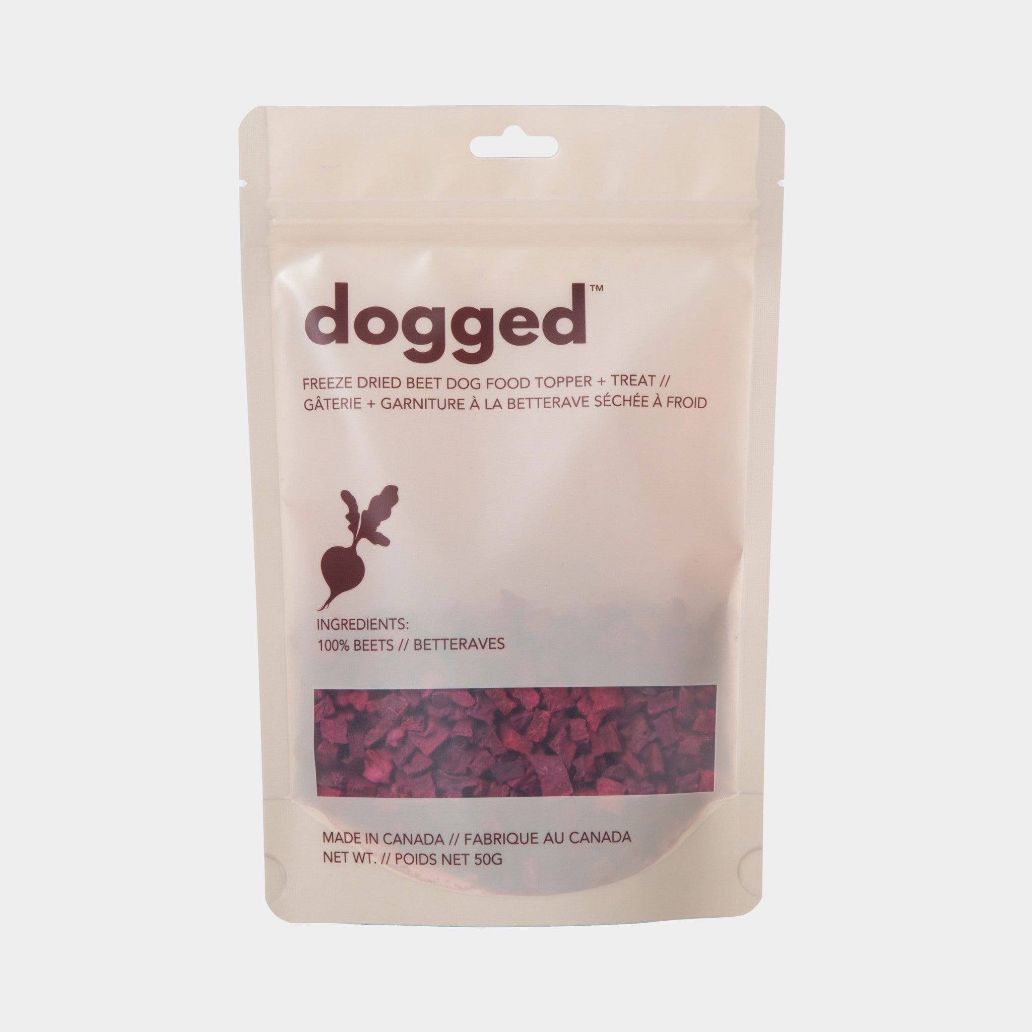 A full front studio shot of the Dogged 50g freeze-dried beet dog food topper packaging, showcasing the clean white minimalist design, bilingual English and French text, and a clear window showing the dark red diced beets inside.