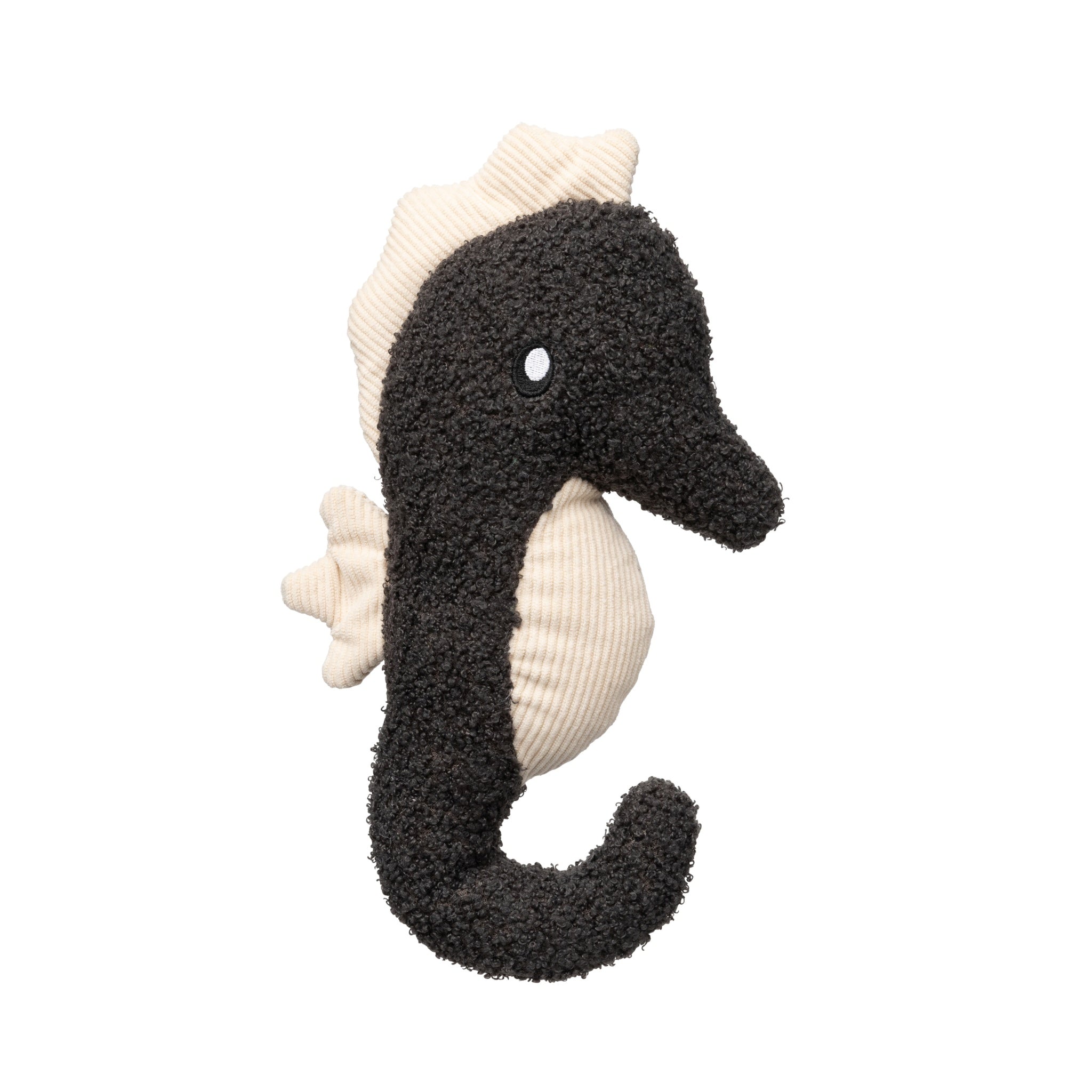 A studio profile view of the FuzzYard Life Slate Grey Seahorse plush dog toy against a white background, featuring its dark charcoal boucle textured body, embroidered eye, and cream corduroy fins and belly.