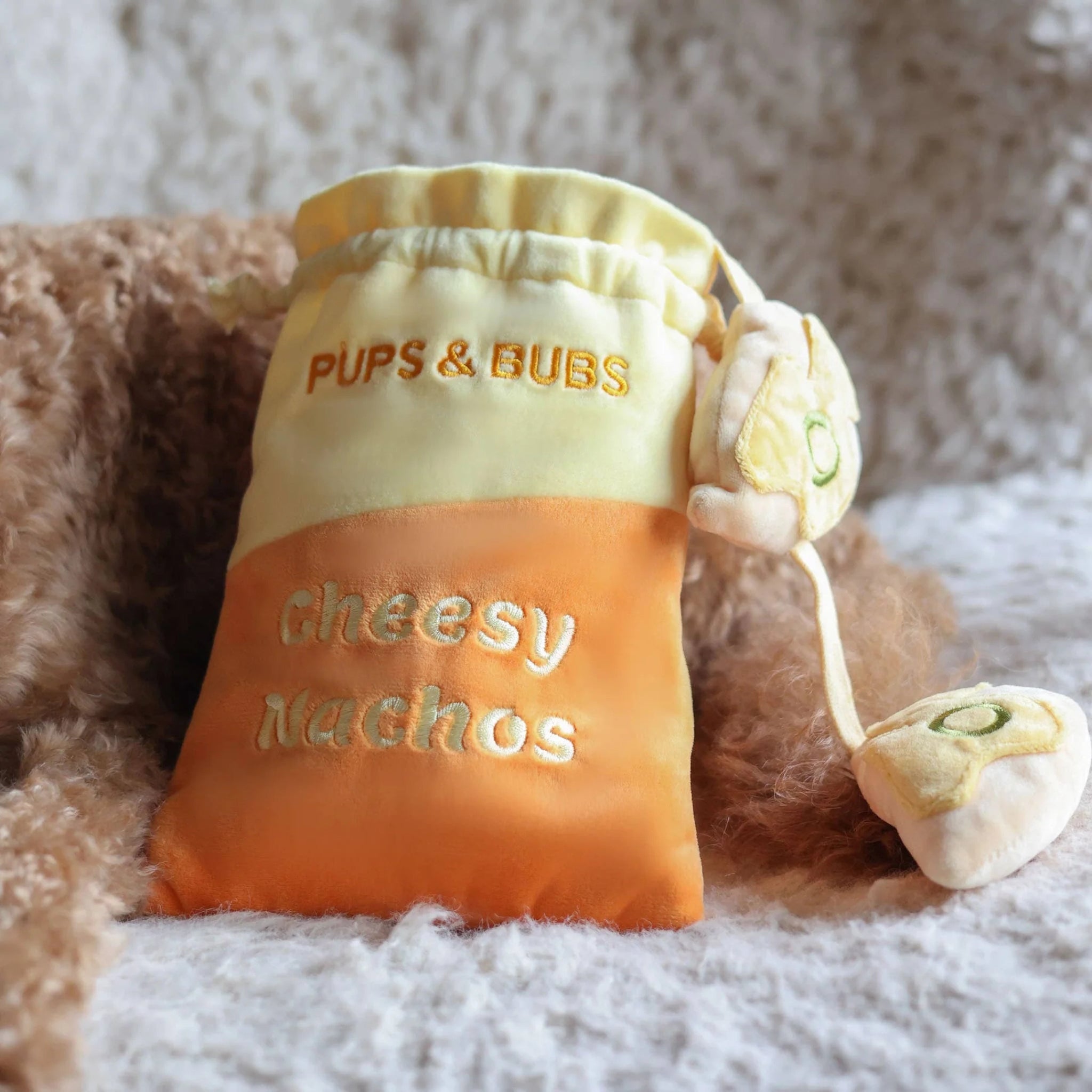 Close-up of the ultra-soft plush fabric and detachable treat-hiding pieces of the Cheesy Nachos nosework dog toy.