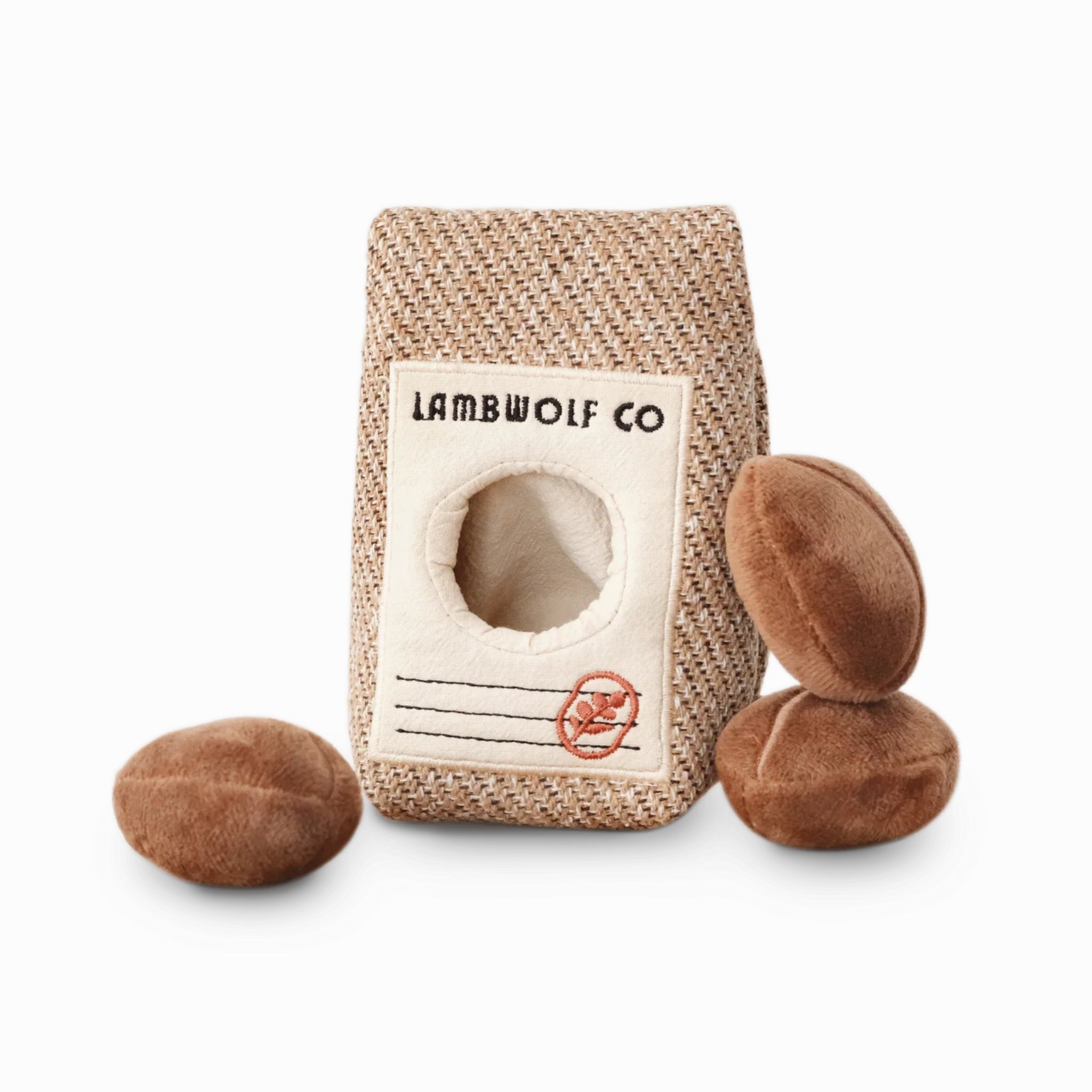 Studio product shot on a plain white background showcasing the neutral tone coffee sack hide-and-seek pet toy and three loose plush coffee bean squeakers.