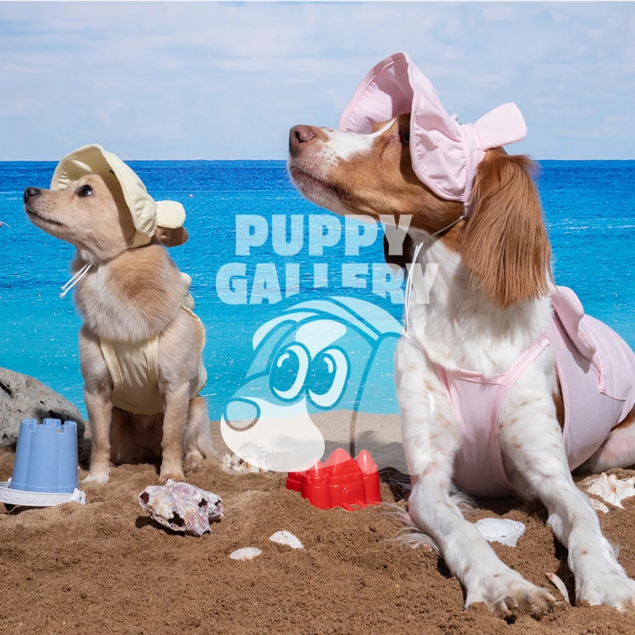 Two dogs posing on a sandy beach by the ocean wearing the yellow lemonade and pastel pink Big Bear cooling dog tank tops with matching summer sun hats.