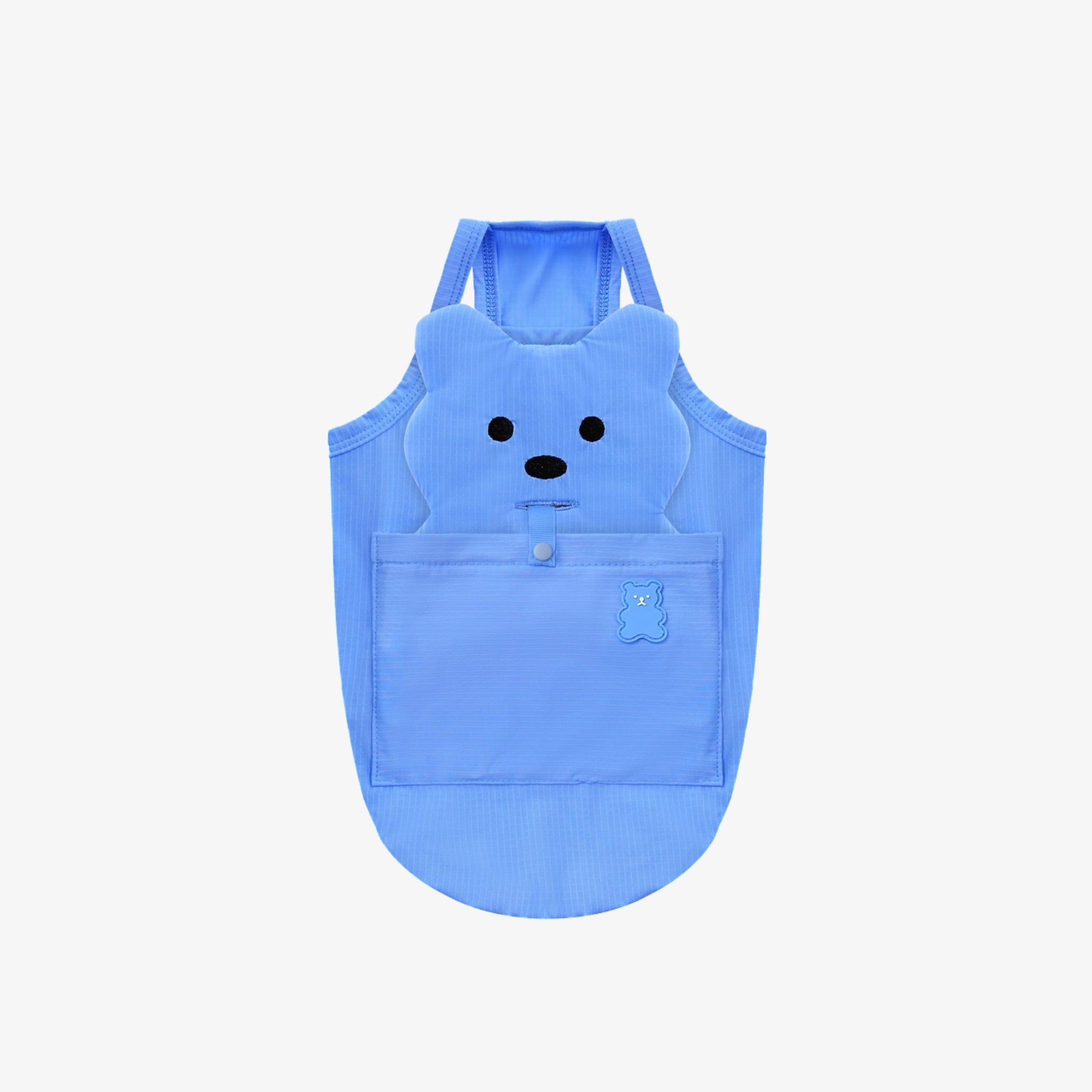 A flatlay view of the light blue Big Bear Cooling Dog Tank Top by Puppy Gallery, featuring a bear-shaped back detail with embroidered facial features and a snap-pocket design on a plain background.