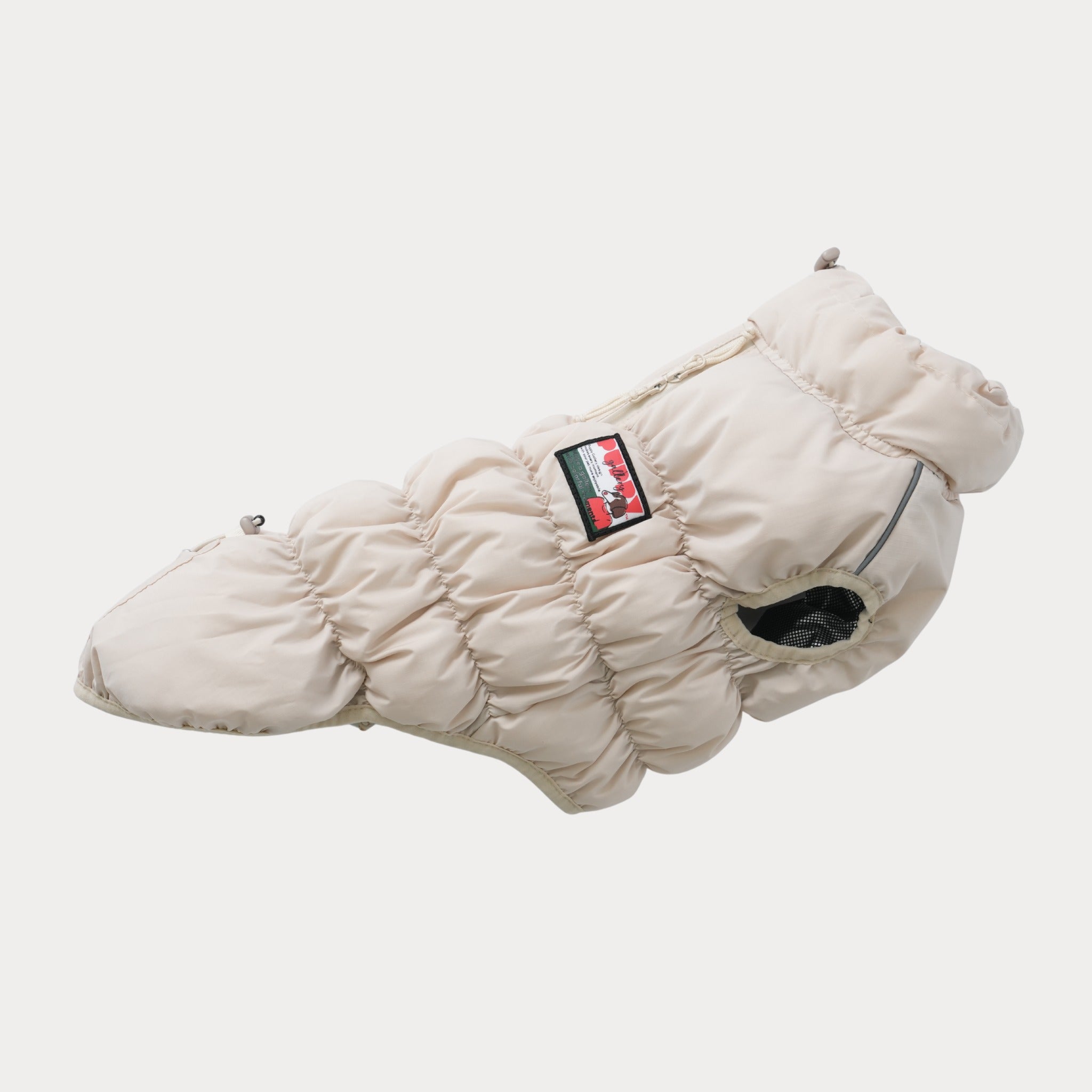 An isolated side view of the empty beige Kiroro 2.0 dog puffer vest, showcasing its quilted cloud-like layers, elastic leg openings, and breathable mesh armhole trim.